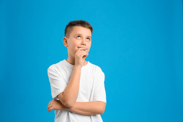 Portrait of preteen boy on light blue background, space for text - Foto, imagen