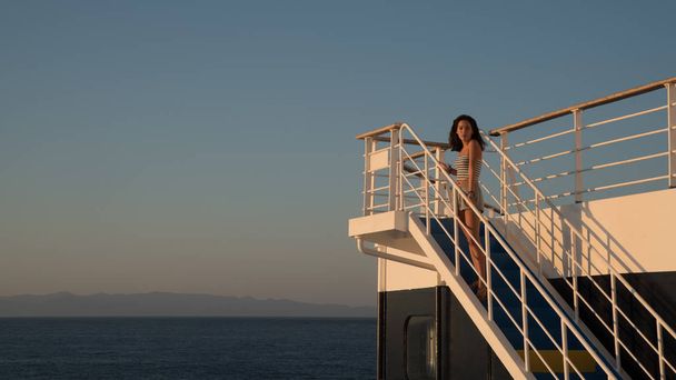 Dospívající dívka v kraťasech stojící na vrcholu modrého schodiště na trajektu bo - Fotografie, Obrázek