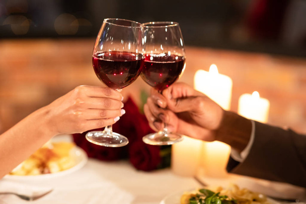Namorado irreconhecível e namorada Clinking óculos durante o jantar interior, close-up
 - Foto, Imagem