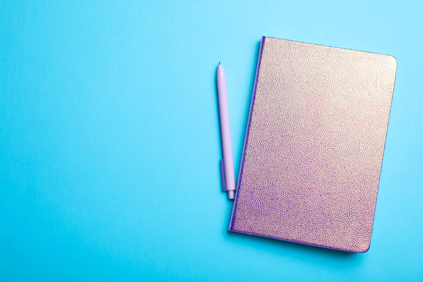 Stylish glitter notebook and pen on light blue background, flat lay. Space for text - Foto, Imagen