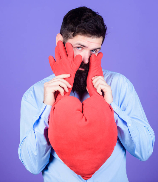 Feeling shy. Bearded man holding big red heart. Love sickness and heart problems. Valentines man expressing love on 14 february. Having heart attack and heartache - Fotoğraf, Görsel
