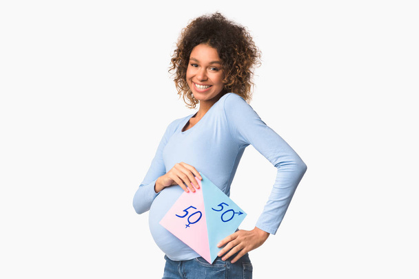 Счастливая будущая женщина держит бумагу с вопросами мальчик или девочка
 - Фото, изображение
