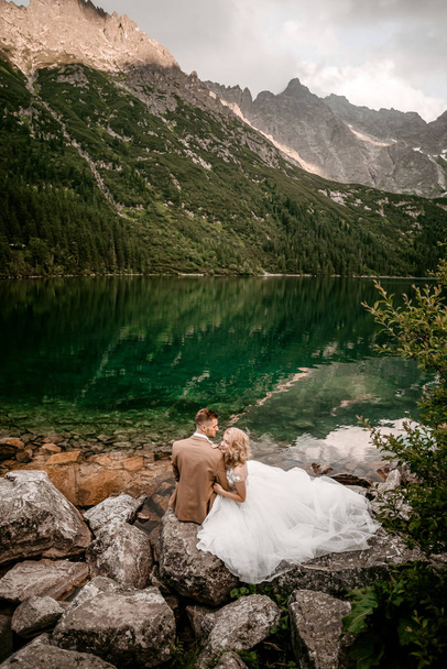 Amazing young couple of lovers on lake Morskie Oko in the Tatra Mountains, en el sur de Polonia. - Foto, imagen