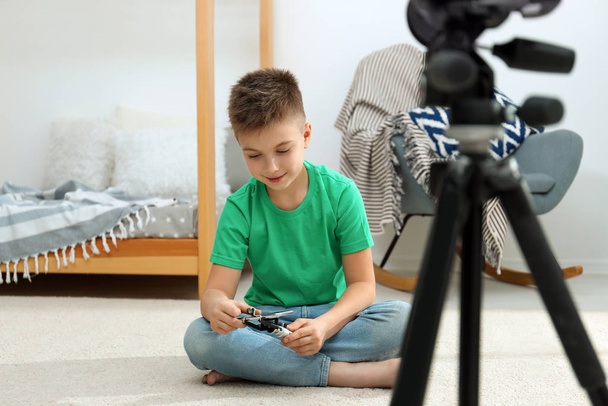 Cute little blogger with phone and selfie stick recording video at home - Foto, Imagen