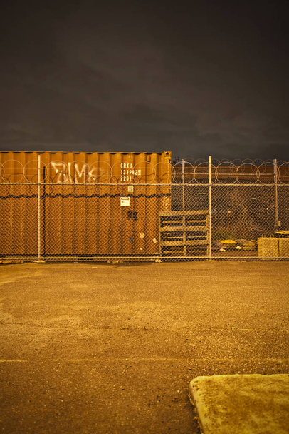 Teollisuusalue yöllä hehkuvilla katuvaloilla
 - Valokuva, kuva