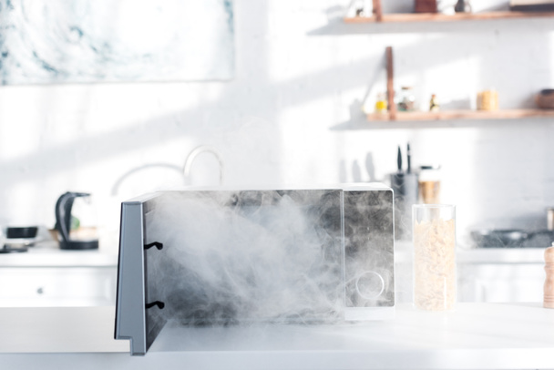 broken and steamy microwave on table in kitchen  - Fotografie, Obrázek