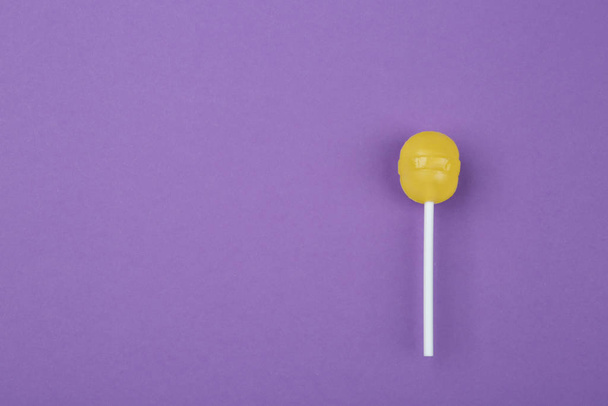 Tasty lemon lollipop on purple background, top view. Space for t - Fotó, kép