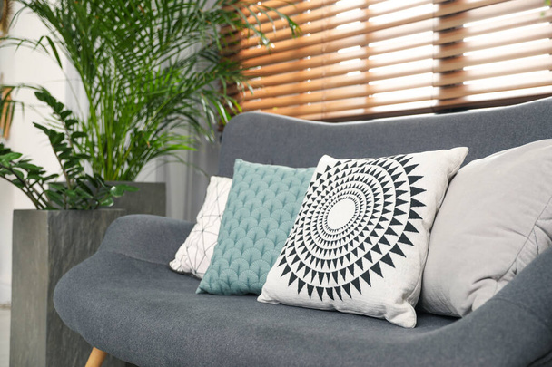 Stylish decorative pillows on grey couch indoors, closeup - Photo, image