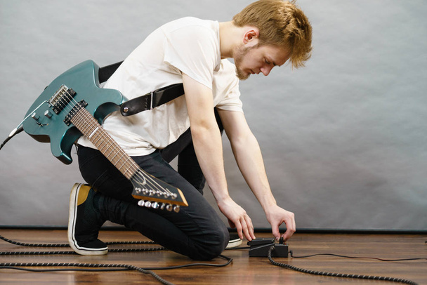 Man adjusting guitar effects pedal - Valokuva, kuva