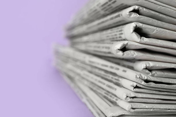 Montón de periódicos sobre fondo violeta claro, primer plano. Diario Oficial
 - Foto, Imagen
