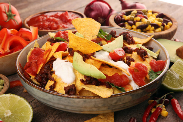 meksikolainen nacho pelimerkkejä koristeltu jauhettua naudanlihaa, guacamole, sulaa
 - Valokuva, kuva