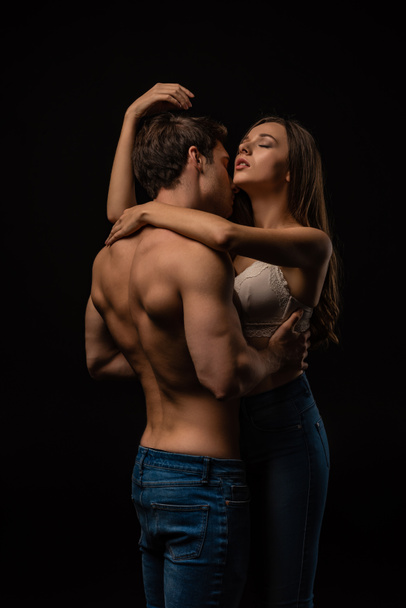 sexy young couple passionately hugging with closed eyes isolated on black - Fotoğraf, Görsel