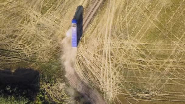 Vista aérea de um caminhão dirigindo na estrada de terra entre campos arados fazendo muito pó
. - Filmagem, Vídeo