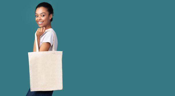Afro Woman Holding Canvas Tote Bag Standing, Turquoise Background, Panorama - Foto, Bild