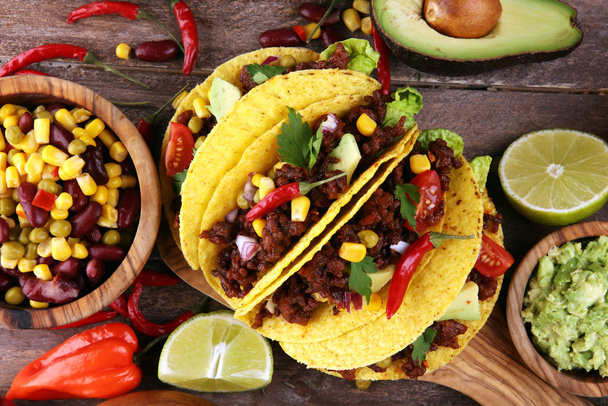 Meksikolaisia tacoja naudanlihalla, tomaateilla, avokadolla, chilillä ja sipulilla. H
 - Valokuva, kuva