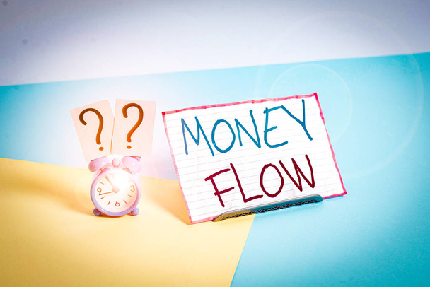 Käsiala teksti Money Flow. Käsitteellinen kuva rahan määrän kasvu tai väheneminen yrityksen Mini-kokoinen herätyskello pastellitaustalle kallistetun paperilevyn vieressä
 - Valokuva, kuva