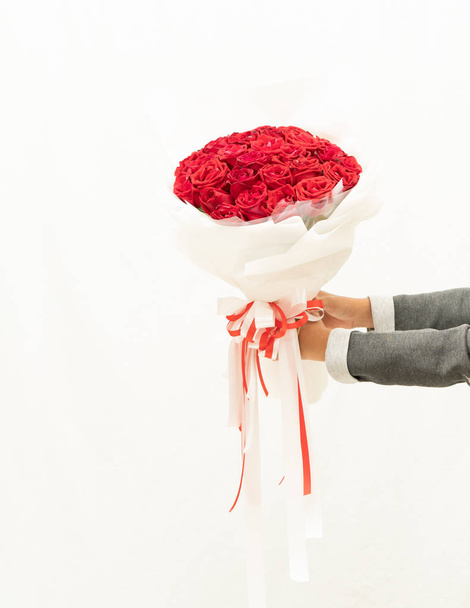 Κόκκινο τριαντάφυλλο στο χέρι σε λευκό φόντο, - Φωτογραφία, εικόνα