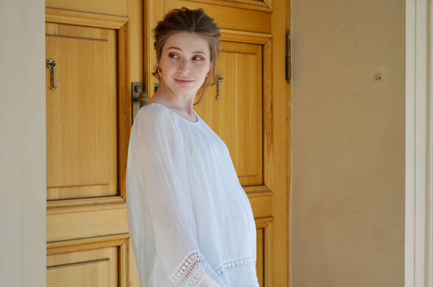 Chica embarazada con una blusa blanca. Chica rubia. Jovencita
. - Foto, Imagen