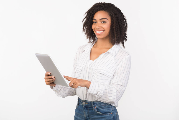 Χαμογελαστό μαύρο κορίτσι στέκεται με tablet στο στούντιο - Φωτογραφία, εικόνα