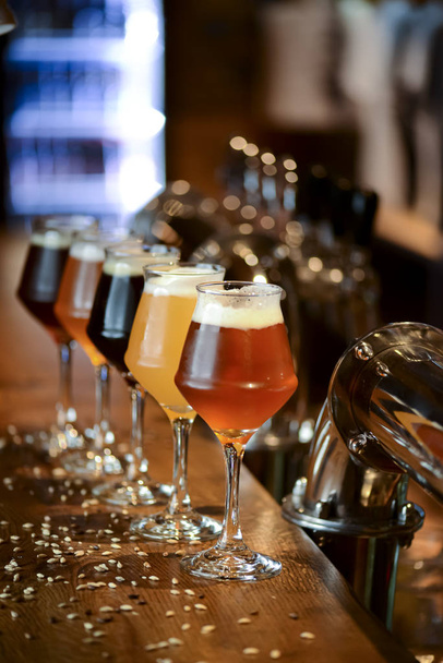 Три бокала с разным пивом на деревянном столе в баре. Концепция пищевой фотографии с копировальным пространством
 - Фото, изображение