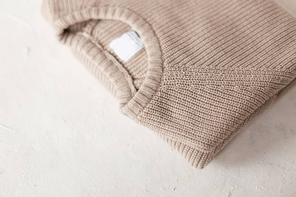 Men's fashionable beige knitted sweater on white background. Stylish knit menswear. New fashion collection handmade knitwear. Details of the everyday look. Close-up. - 写真・画像