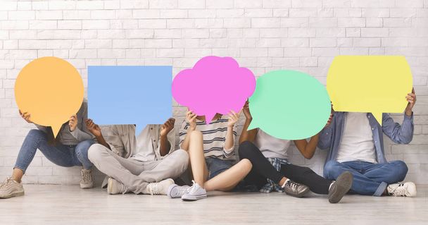 Group of students covering faces with colorful speech bubbles - Photo, Image
