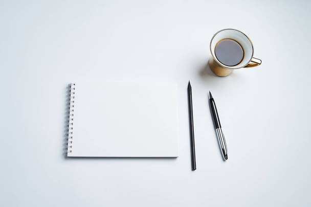 white office Desk top view with Notepad, pen, pencil and coffee Cup, minimalistic design, top view,copy space,flat lay - Zdjęcie, obraz
