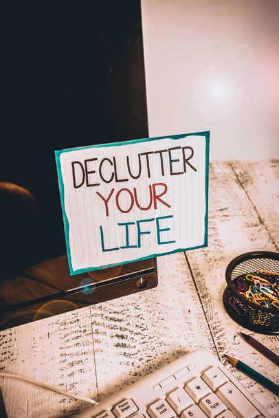 Word writing text Declutter Your Life. Business photo showcasing To eliminate extraneous things or information in life Note paper taped to black computer screen near keyboard and stationary - Photo, Image