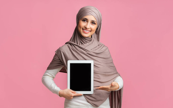 Siyah ekranlı dijital tableti işaret eden tesettürlü Müslüman kız - Fotoğraf, Görsel