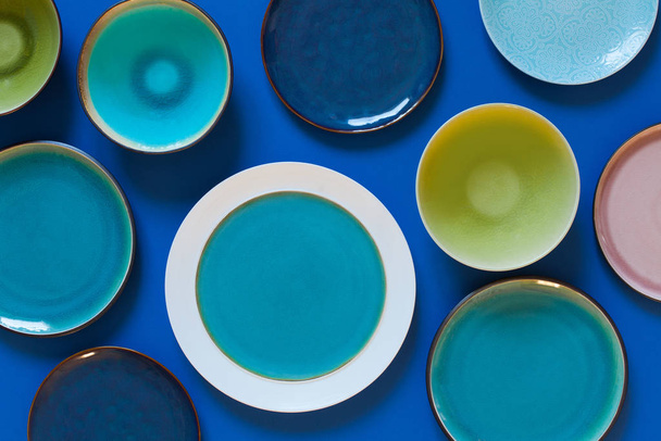 Empty flat and deep plates on a blue background. - Foto, imagen