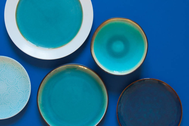 Empty flat and deep plates on a blue background. - 写真・画像
