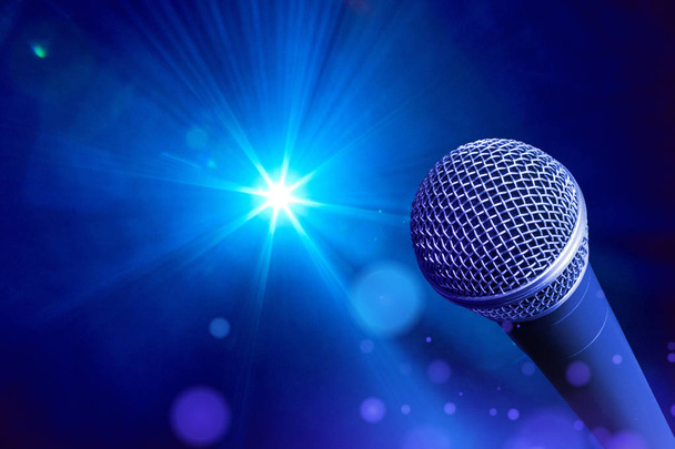 Microfone vocal na frente de luzes de palco em tons azuis
 - Foto, Imagem