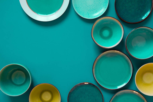 Empty flat and deep plates on a aquamarine background. - Foto, Imagen
