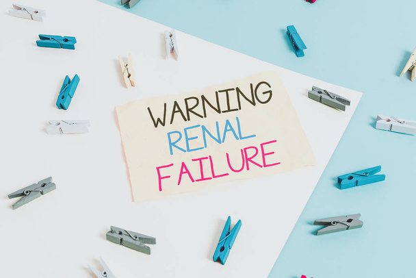 Handwriting text writing Warning Renal Failure. Conceptual photo stop Filtering Excess Waste Acute Kidney malfunction Colored clothespin paper empty reminder yellow blue floor background office - Photo, Image