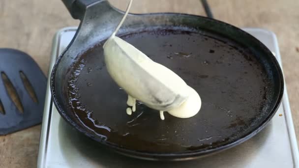 Pouring dough for a pancake on pan - Πλάνα, βίντεο