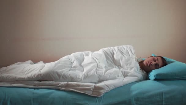A fiatalember egy rémálomból ébred fel. Tovább alszik az ágyon. - Felvétel, videó