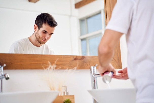 Young man washing hands in bathroom - Foto, Imagem