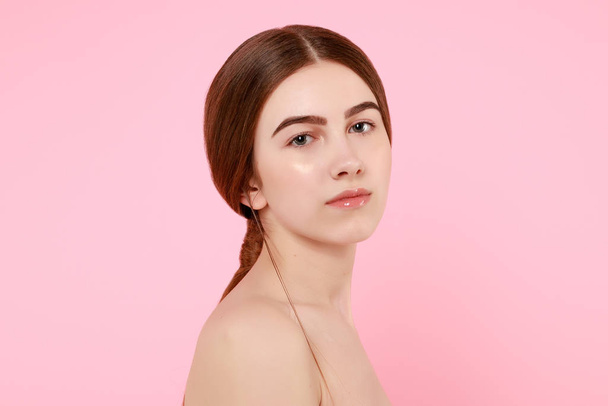 Beautiful young girl touching her perfect skin on pink background. - Zdjęcie, obraz