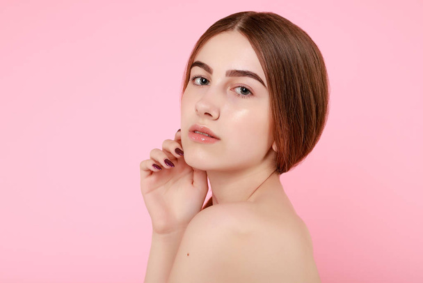 Beautiful young girl touching her perfect skin on pink background. - Foto, Imagem