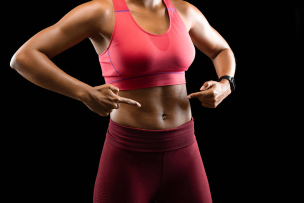 Kobieta model fitness wskazując na jej sześciopak - Zdjęcie, obraz