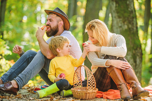 Good day for spring picnic in nature. Family day concept. Happy family with kid boy relaxing while hiking in forest. Family weekend. Mother father and little son sit forest picnic. United with nature - Foto, afbeelding