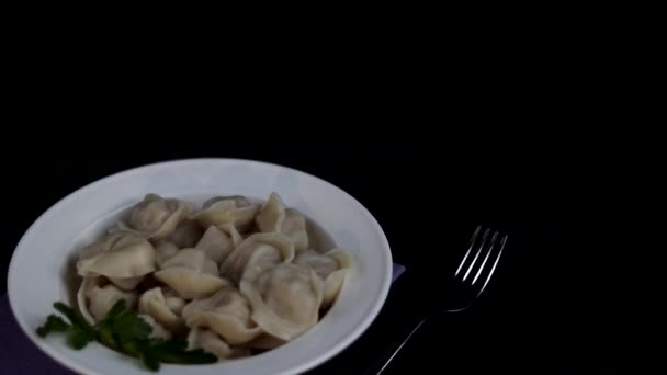 Hot khinkali with spinach in a white plate. On top are pieces of melting butter. You can see how steam comes from a hot product. - Video
