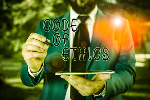 Notatka z Kodeksem Etyki. Business concept for Morral Rules Ethical Integrity Uczciwość Dobra procedura Biznesmen w niebieskim apartamencie stoi z telefonem komórkowym w rękach - Zdjęcie, obraz