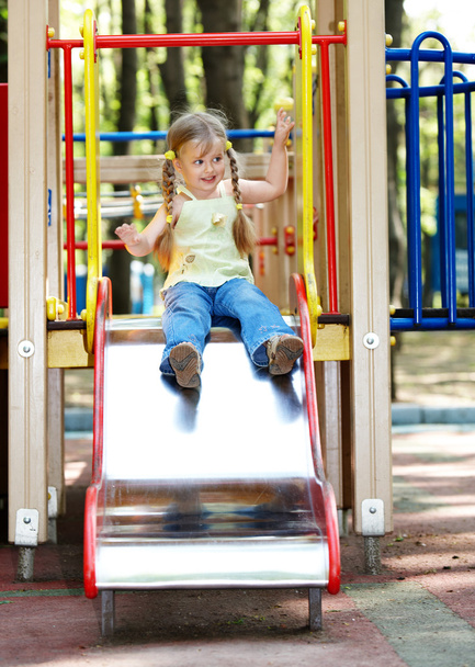 Дитина на слайді на відкритому повітрі в парку
. - Фото, зображення