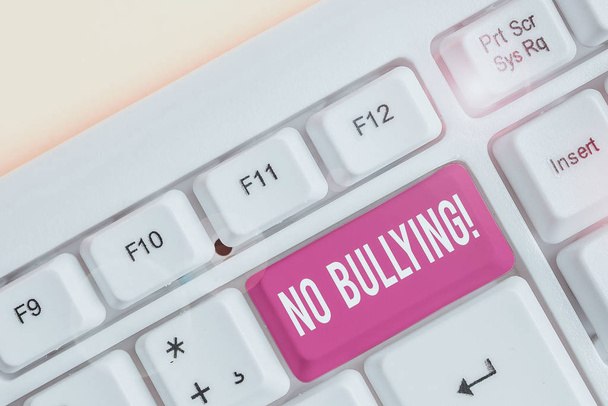 Word writing text No Bullying. Business photo showcasing stop aggressive behavior among children power imbalance White pc keyboard with empty note paper above white background key copy space - Фото, изображение