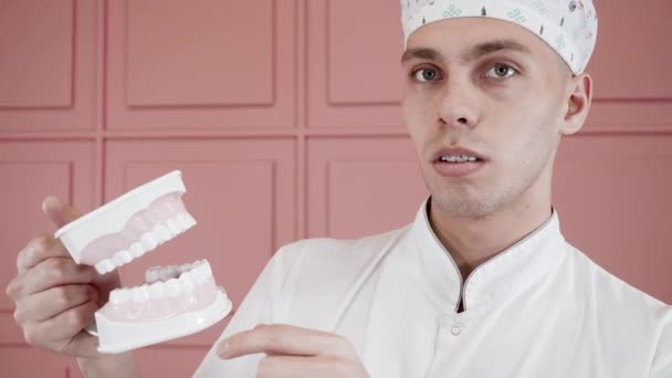 Porträt eines jungen Mannes, der mit Zahnspange lächelt und ein Kieferimplantat schnappt. - Filmmaterial, Video