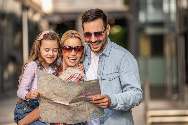 Family of tourists looking for some destination with city map - Photo, Image