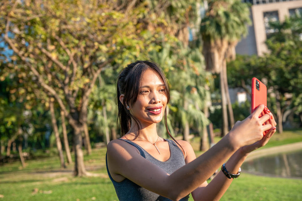 Hermosa mujer joven asiática relajándose y tomando selfies en la c - Foto, Imagen