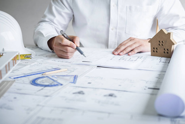 Инженер-строитель или архитектор, работающий над чертежом
 - Фото, изображение