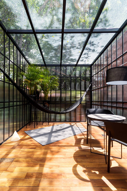 Modern sunroom with a hammock and some plants - Foto, afbeelding